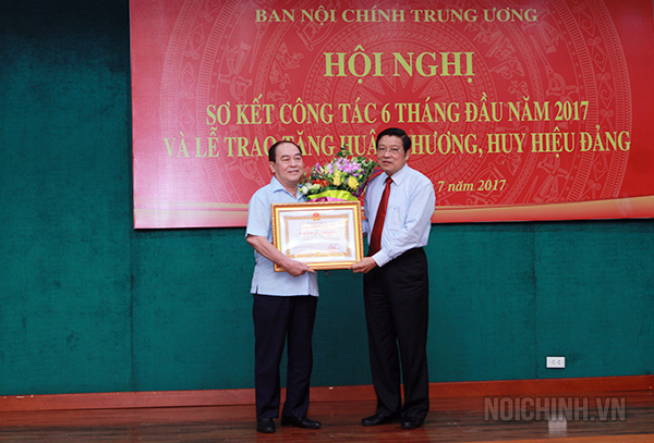 Đồng chí Phan Đình Trạc, Ủy viên Trung ương Đảng, Trưởng Ban Nội chính Trung ương thừa ủy quyền Chủ tịch nước trao Huân chương Lao động hạng Ba cho đồng chí Nguyễn Khắc Hợp, nguyên Vụ trưởng Vụ theo dõi công tác PCTN