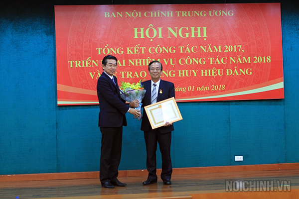 Đồng chí Võ Văn Dũng, Ủy viên Trung ương Đảng, Phó Trưởng ban Thường trực, Bí thư Đảng ủy Cơ quan Ban Nội chính Trung ương trao Huy hiệu 30 năm tuổi Đảng cho đồng chí Đặng Xuân Tính, Phó Vụ trưởng Vụ Công tác phía Nam, Ban Nội chính Trung ương