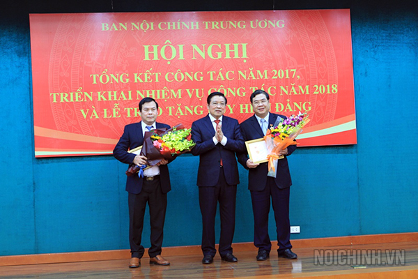 Đồng chí Phan Đình Trạc, Bí thư Trung ương Đảng, Trưởng Ban Nội chính Trung ương trao Kỷ niệm chương Vì sự nghiệp Nội chính Đảng cho đồng chí Phạm Gia Túc, Phó trưởng Ban và đồng chí Trần Văn Lâm (bên trái), Vụ Cơ quan Nội chính, Ban Nội chính Trung ương