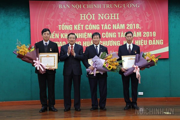 Đồng chí Phan Đình Trạc, Bí thư Trung ương Đảng, Trưởng Ban Nội chính Trung ương, Phó Trưởng ban Thường trực Ban Chỉ đạo Trung ương về phòng, chống tham nhũng, Phó Trưởng ban Thường trực Ban Chỉ đạo Cải cách tư pháp Trung ương trao Huy hiệu 30 năm tuổi Đảng cho 03 đồng chí: Phạm Anh Tuấn, nguyên Phó trưởng Ban Nội chính Trung ương; Vũ Văn Tài, Phó Vụ trưởng Vụ 1; Nguyễn Đức Luân, Phó Vụ trưởng Vụ 7