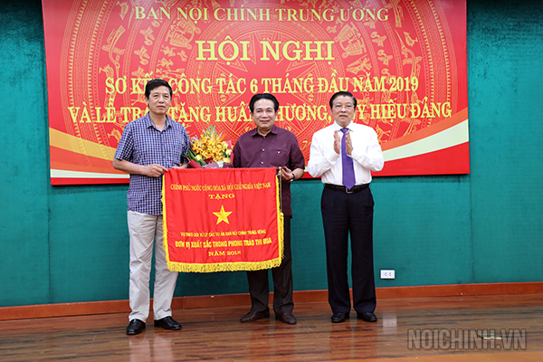 Đồng chí Phan Đình Trạc, Bí thư Trung ương Đảng, Trưởng Ban Nội chính Trung ương, Phó Trưởng ban Thường trực Ban Chỉ đạo Trung ương về phòng, chống tham nhũng, Phó Trưởng ban Thường trực Ban Chỉ đạo Cải cách tư pháp Trung ương thừa ủy quyền Thủ tướng Chính phủ trao Cờ thi đua của Chính phủ cho Vụ Theo dõi xử lý các vụ án, Ban Nội chính Trung ương.