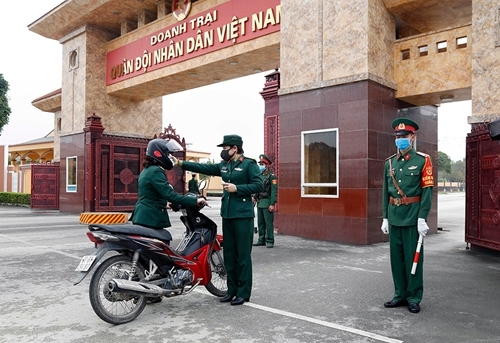 Lực lượng quân y Quân khu 1 tiến hành đo kiểm tra thân nhiệt đối với các quân nhân ra vào cổng doanh trại