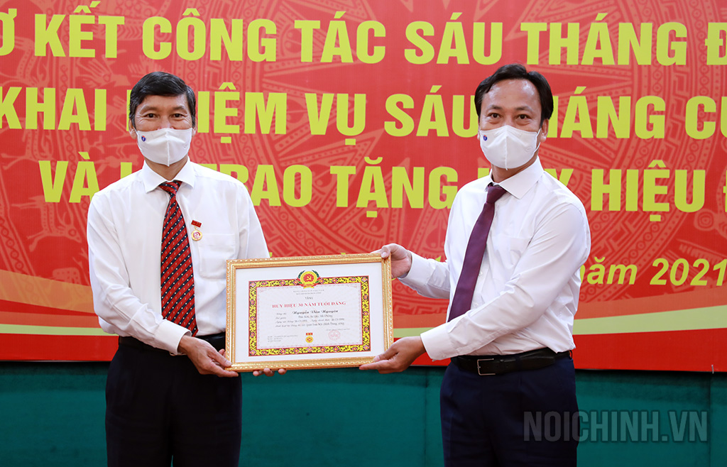 Đồng chí Lại Xuân Lâm, Phó Bí thư Đảng ủy Khối các cơ quan Trung ương trao Huy hiệu 30 năm tuổi Đảng cho đồng chí Nguyễn Văn Nguyên, Phó chánh Văn phòng Ban