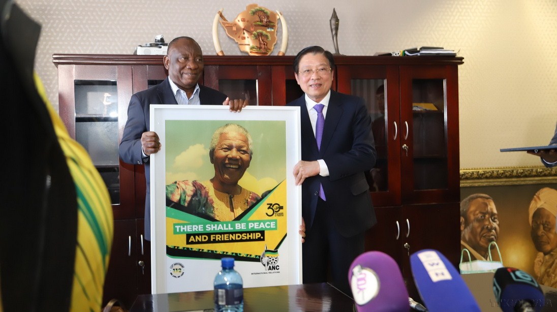 Chủ tịch đảng ANC, Tổng thống Nam Phi Cyril Ramaphosa (trái) tặng quà lưu niệm đồng chí Phan Đình Trạc tại trụ sở đảng